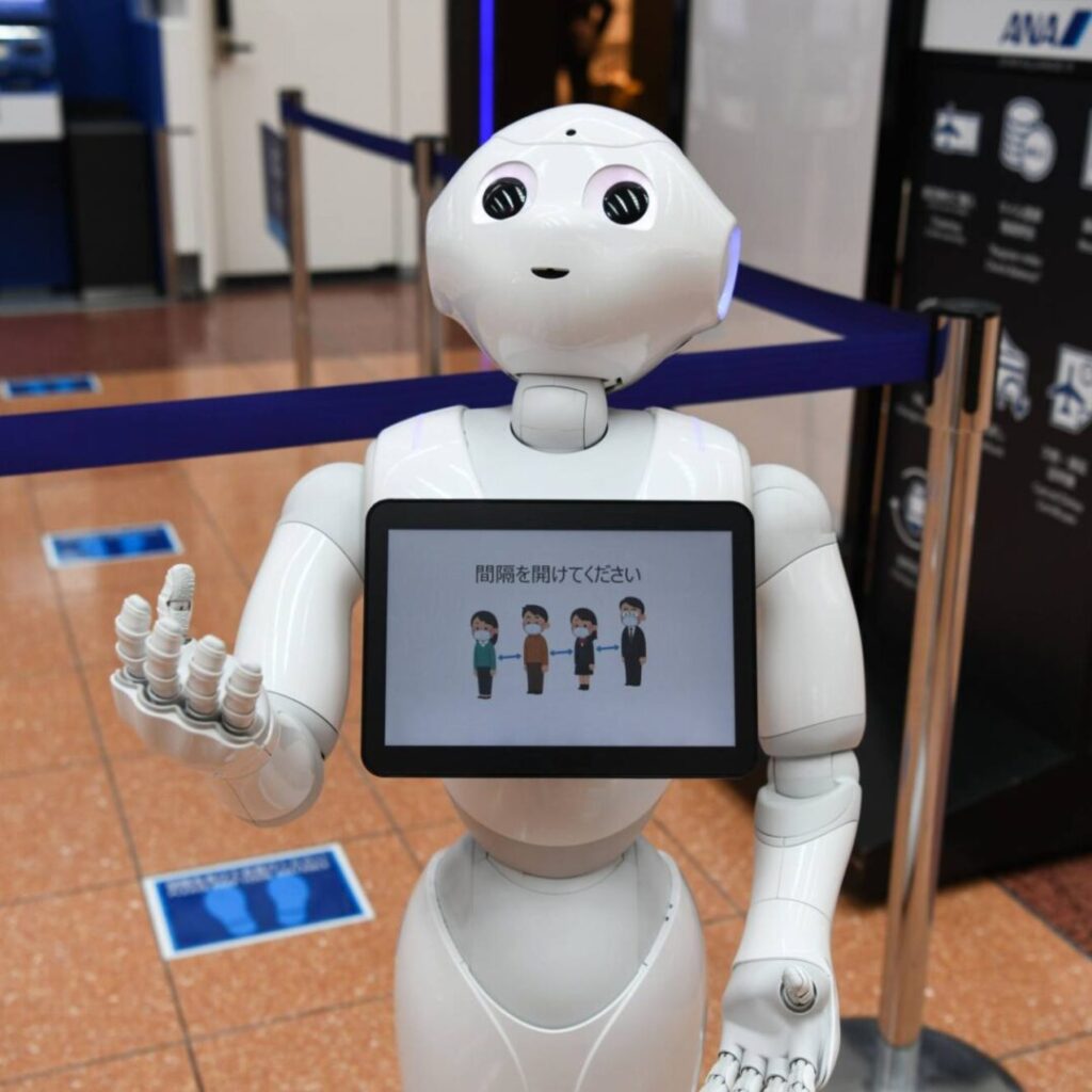 A SoftBank Group Corp. Pepper humanoid robot reminds travelers to social distance at an All Nippon Airways Co. (ANA) check-in area at Haneda Airport in Tokyo, Japan, on Tuesday, July 28, 2020. Concern over the virus situation in Japan in growing as cases have surged in recent weeks. An outbreak initially thought confined to nighttime entertainment areas in Tokyo has spread to workplaces and across the country.